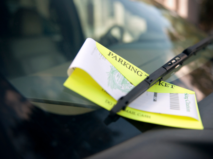 En gul parkeringsbot bak en vindusvisker 